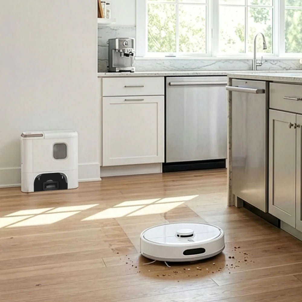 White robotic vacuum cleaner with circular design on wooden kitchen floor surrounded by scattered debris, with white kitchen cabinets, stainless steel appliances, and matching white charging dock in background