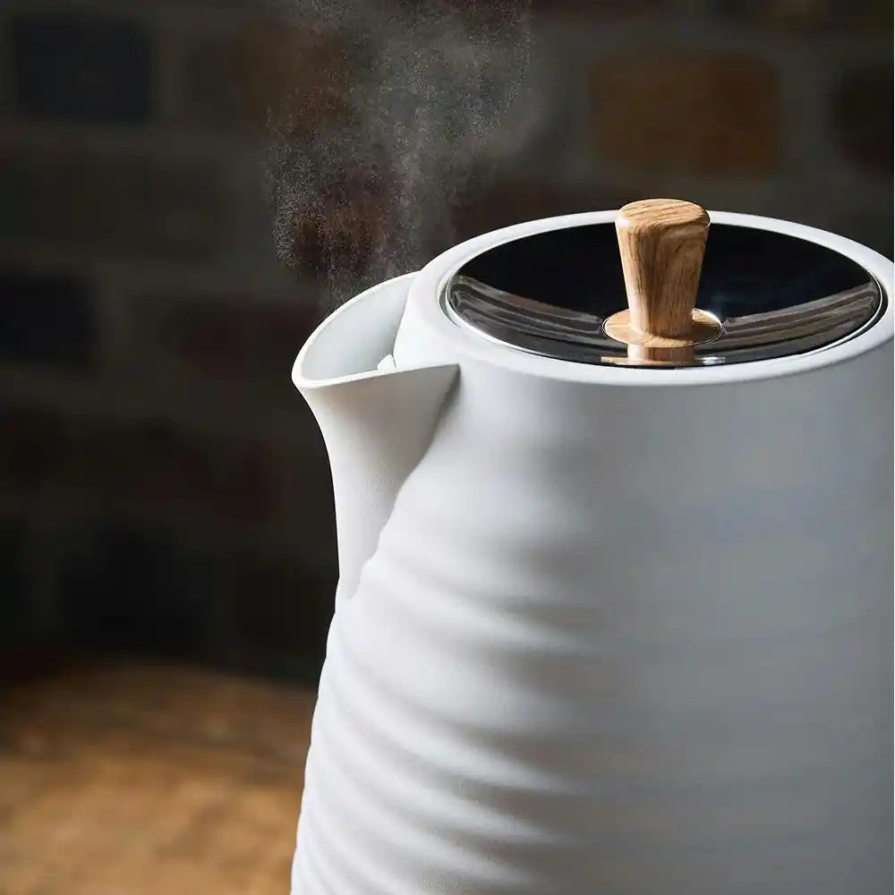 Morphy Richards Clay Flint white jug kettle with wooden handle and black lid, steam rising from spout, modern design on wooden surface