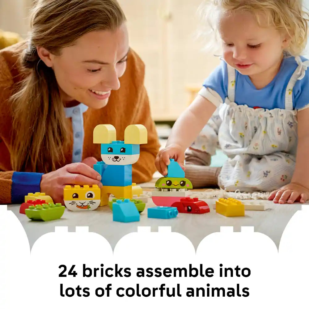 Adult and toddler playing with colorful LEGO DUPLO brick animals including a blue mouse with yellow ears, yellow cat face, and green caterpillar made from 24 large building blocks on white surface