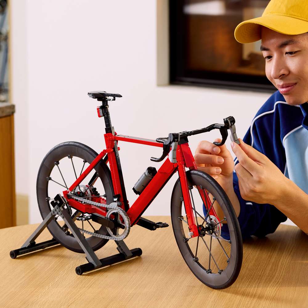 LEGO Icons Road Bike 11380 - a child playing with the finished build. 1015 pieces. Ages 18+.