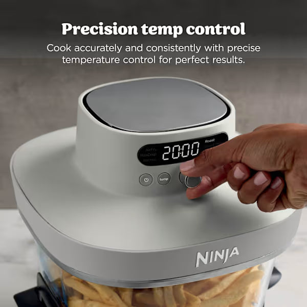 Ninja CRISPi PRO 7 in 1 XL Glass Air Fryer in white and bone grey with digital display showing 20:00, featuring precision temperature control buttons being adjusted by a hand, displayed on marble countertop with food visible in glass cooking vessel