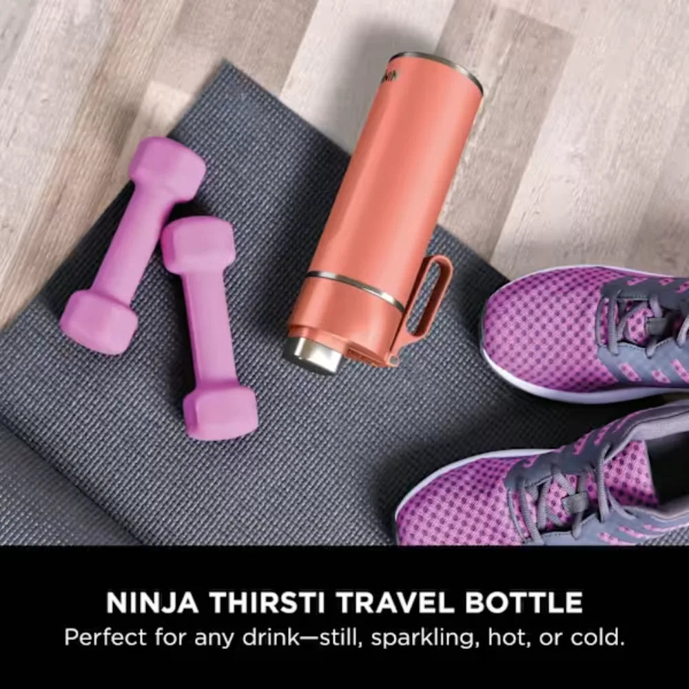 Ninja Thirsti 530ml insulated travel bottle in coral displayed on grey yoga mat with pink dumbbells and purple running shoes, designed for hot and cold beverages