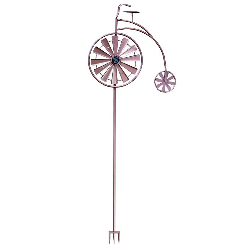 Purple metal penny farthing bicycle wind spinner with large front wheel and small rear wheel, featuring solar-powered design with ground stake base