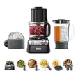 Kenwood food processor with attachments and prepared meals on a white background