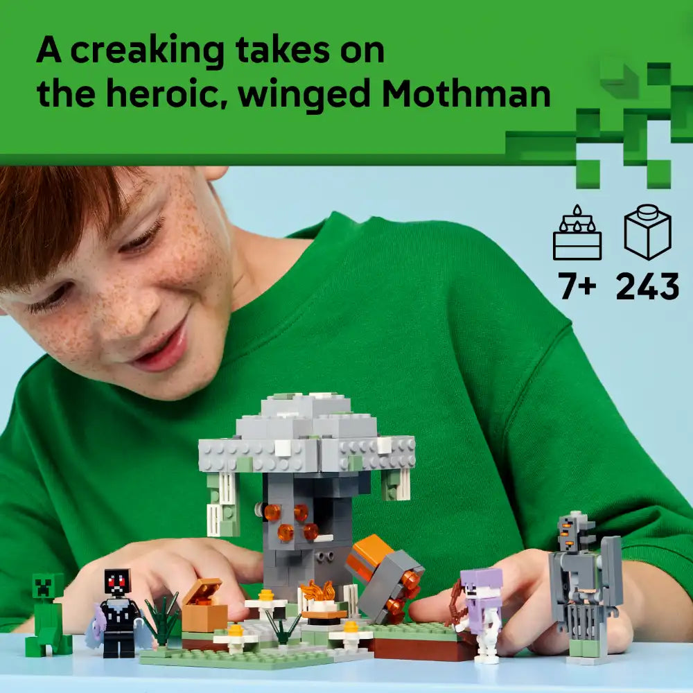 Child in green shirt playing with LEGO Minecraft The Pale Garden set featuring grey and white building blocks, Mothman minifigure with wings, orange flames, creeper figure, and landscape accessories on blue surface, 7+ age rating, 243 pieces