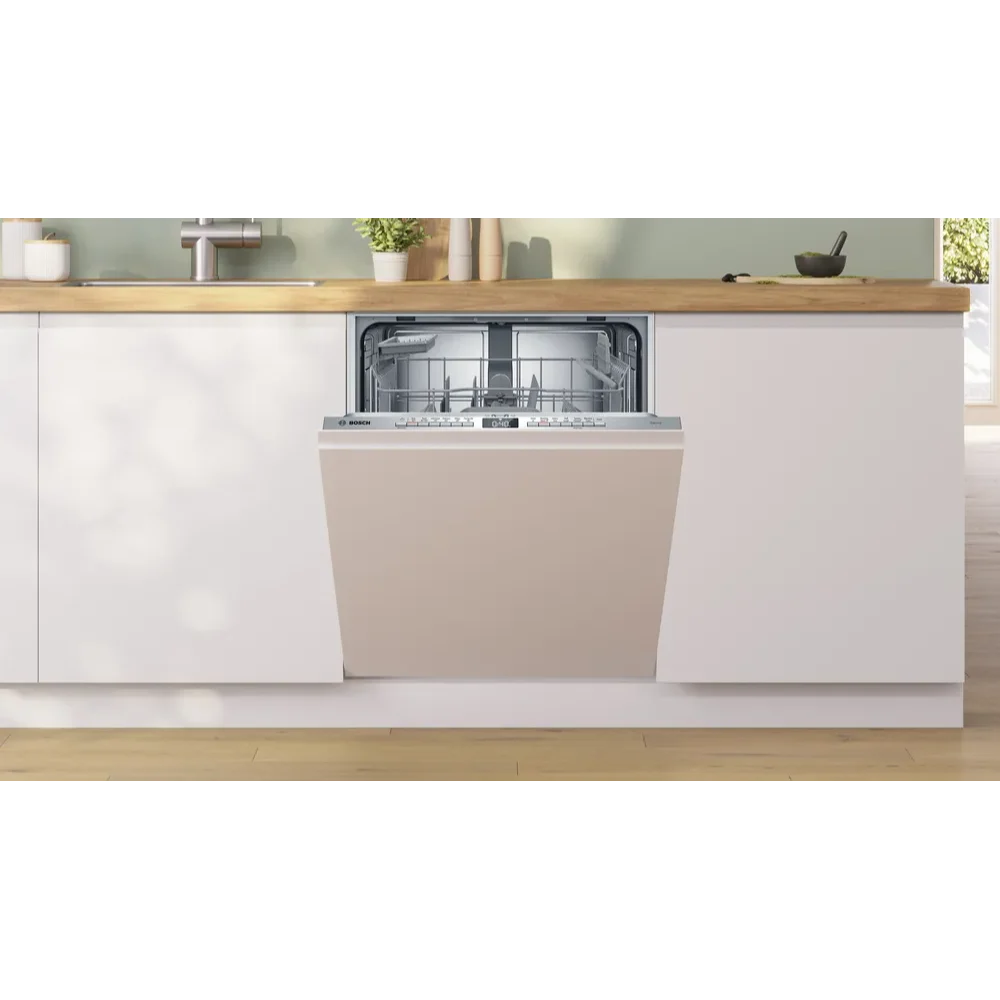 Bosch Serie 4 integrated dishwasher with stainless steel control panel and grey interior, fully built-in to white kitchen cabinetry with wooden countertop and open shelving displaying plants and kitchen accessories