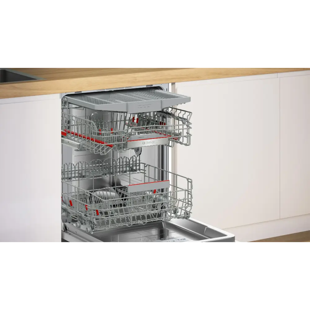 Bosch Series 6 integrated dishwasher with stainless steel interior and red handles, partially open showing upper and lower wire baskets, installed under wooden countertop in modern white kitchen cabinetry