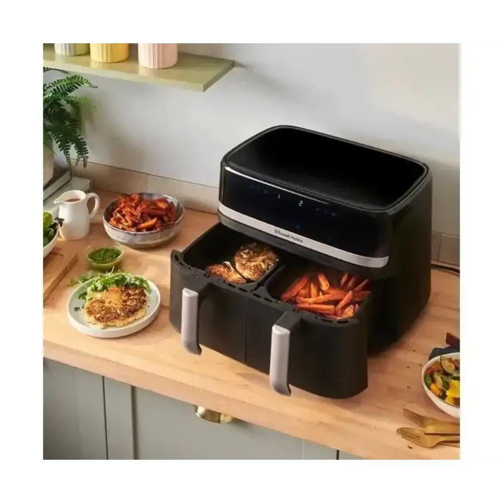 Russell Hobbs Satisfry Dual Basket Air Fryer 9 Litre in black and silver displayed on wooden kitchen counter with cooked food in baskets, surrounded by prepared dishes and kitchen accessories