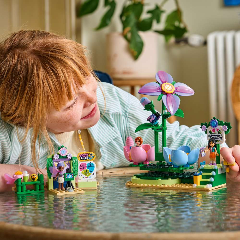 LEGO Friends Spinning Flower & Fairy Teacup Ride 42702 - a child playing with the finished build. 321 pieces. Ages 7+.