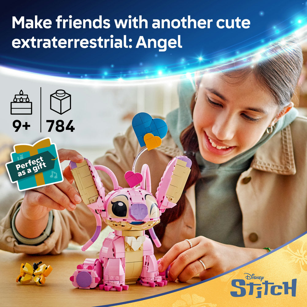 LEGO buildable Angel figure in pink and tan with blue heart-shaped head, sitting on wooden table next to small yellow companion figure, girl smiling while playing with toy, age 9+ set with 784 pieces, Disney Stitch themed construction toy