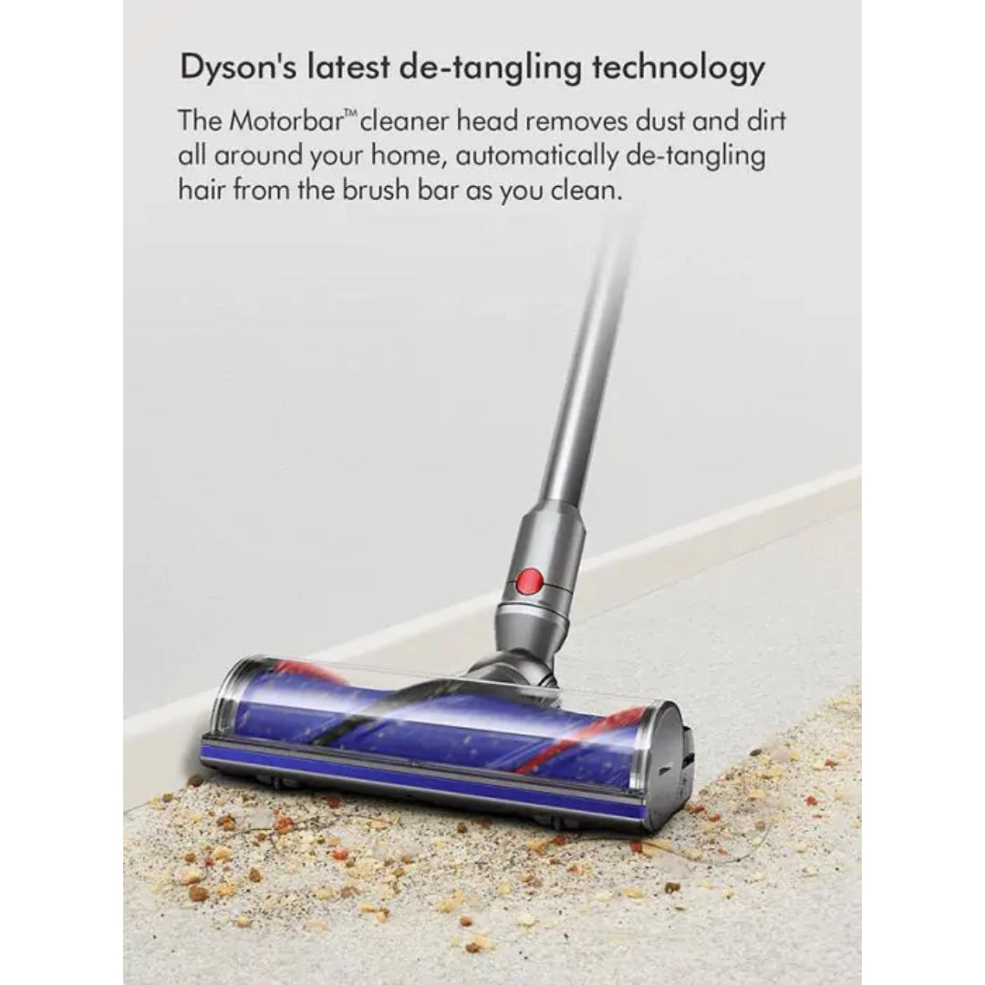 Dyson V12 Detect Slim vacuum cleaner with blue and red Motorbar cleaner head removing dust and debris from light grey floor, demonstrating automatic hair de-tangling technology