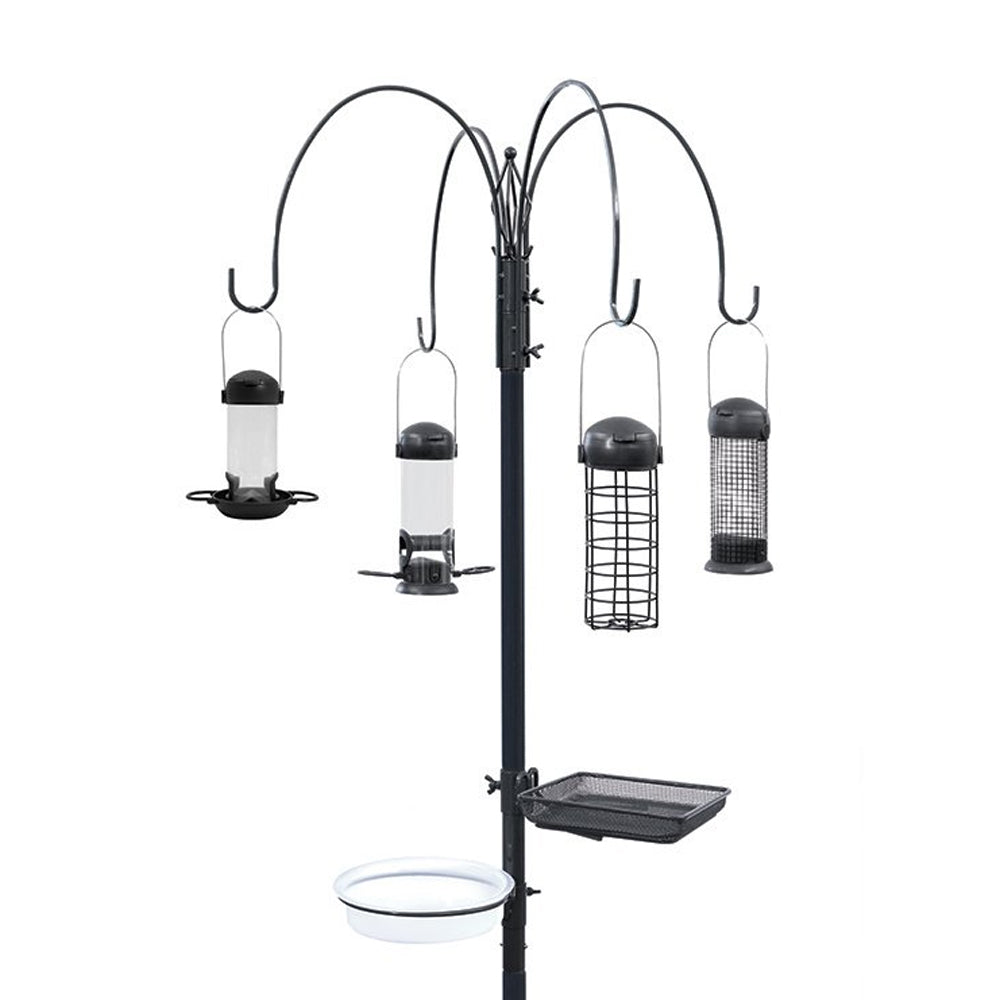 Black metal bird feeding station with four hanging feeders in various styles including tube and cage feeders, featuring a central pole with attached tray and water basin, displayed against white background