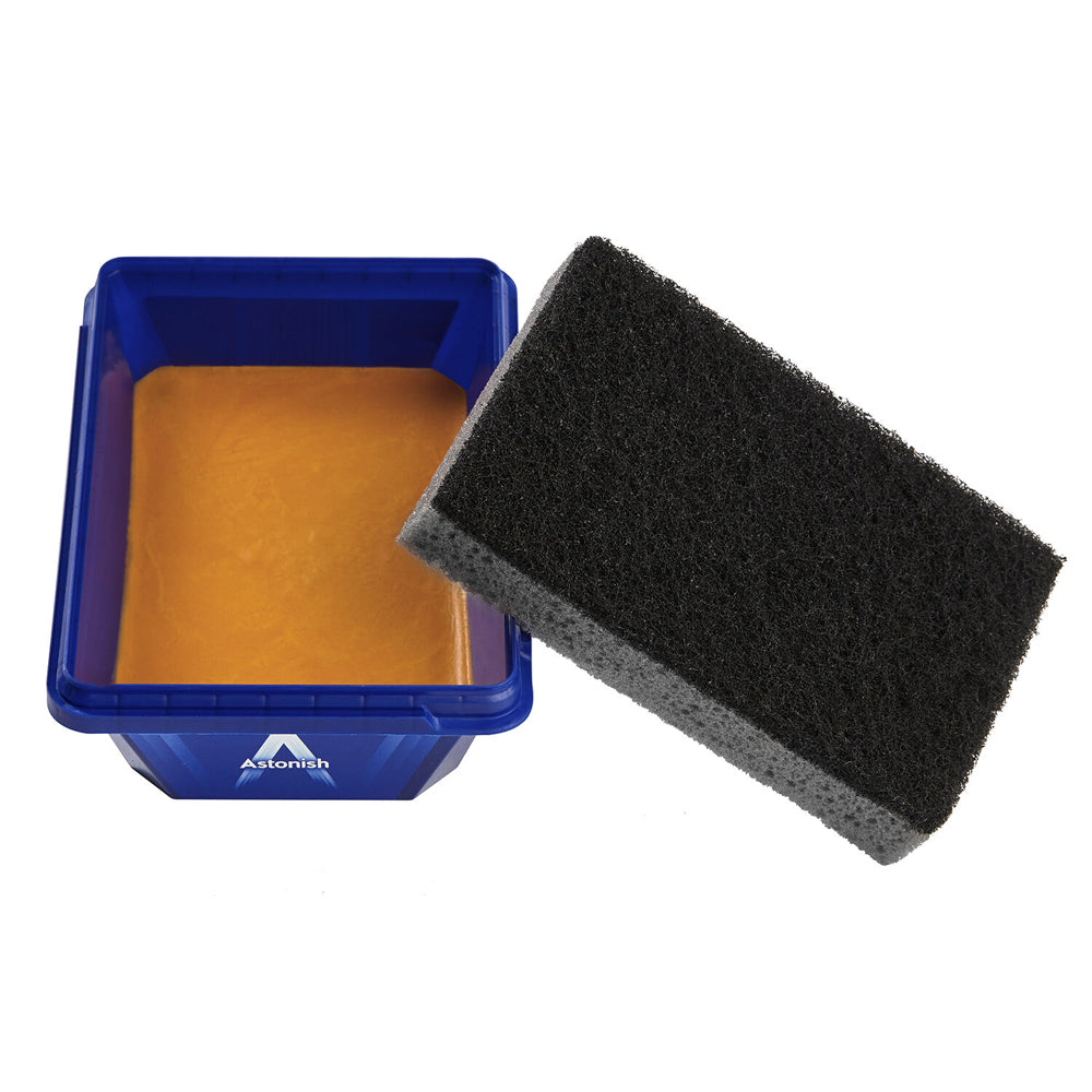 Astonish Specialist Oven and Grill Cleaner 250g with blue container filled with orange cleaning paste and black textured scrubbing sponge