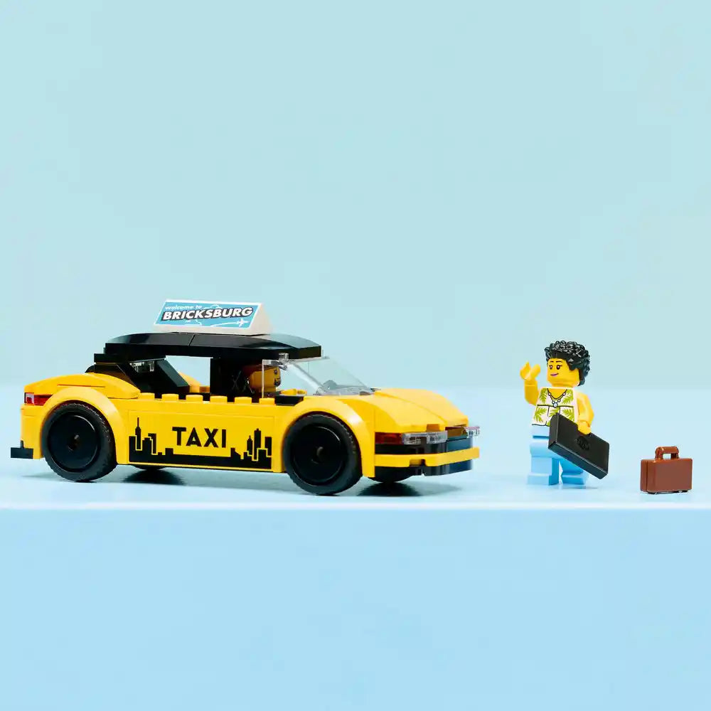LEGO yellow taxi set 60487 featuring a brick-built yellow and black taxi car with retractable roof, minifigure driver with black curly hair in yellow outfit, small brown suitcase, and Bricksburg sign on light blue background