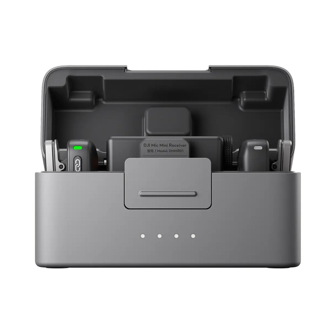 DJI Mic Mini wireless microphone system showing gray charging case with two black transmitters with green battery indicators and one black receiver unit labeled DMMR01 inside protective foam compartments