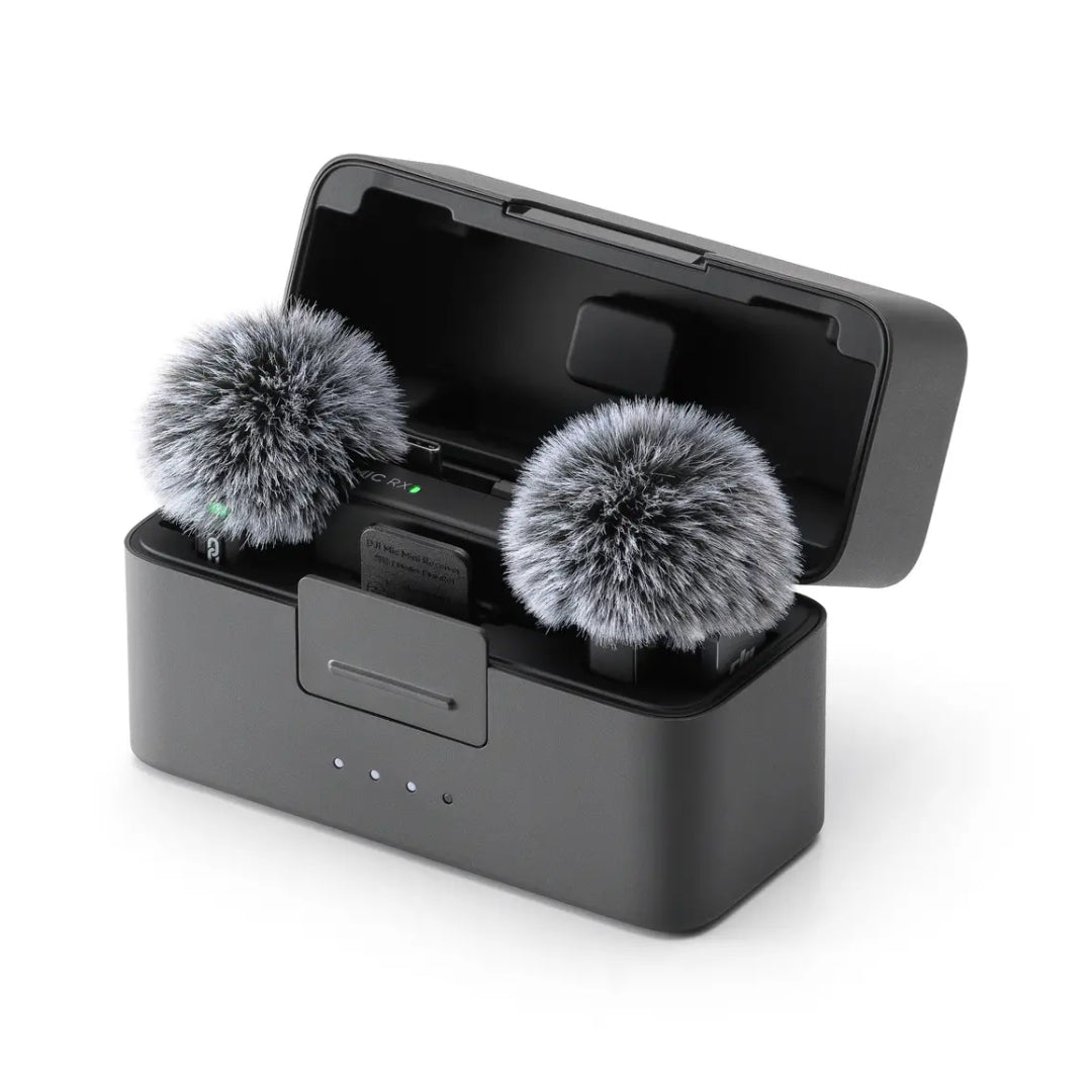 DJI Mic Mini wireless microphone system with two black transmitters featuring gray windscreen covers in open charging case with receiver, displayed against white background