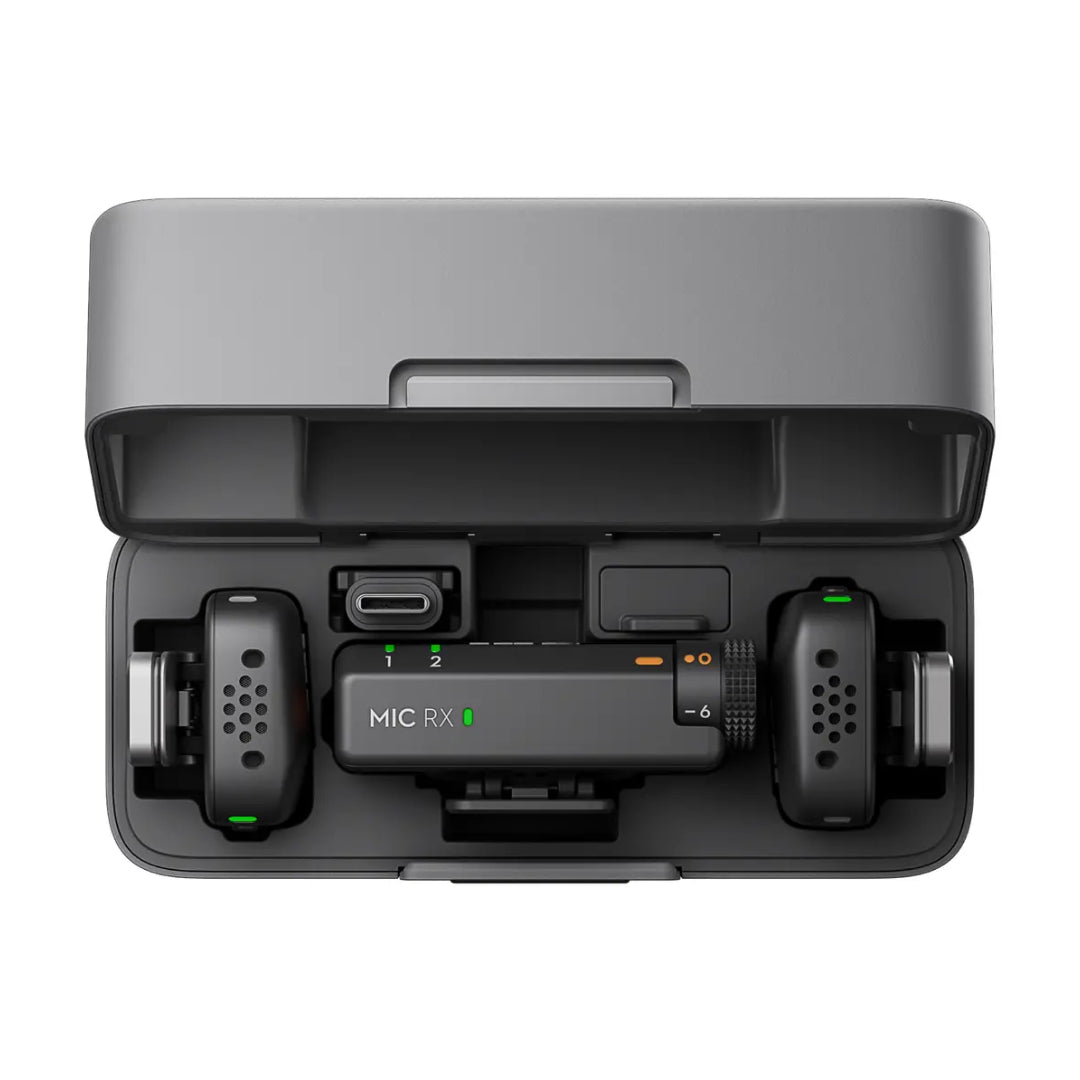 DJI Mic RX wireless microphone system with two black transmitter units and one receiver displayed in gray charging case with green indicator lights