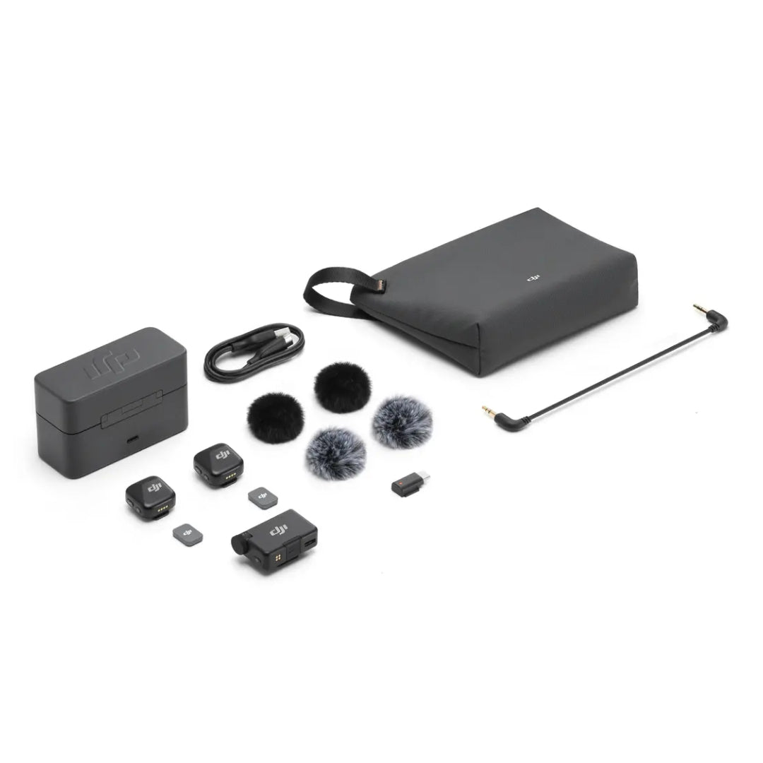 DJI Mic Mini 2-person wireless microphone system layout showing two black transmitter units, one receiver unit, charging case with carrying strap, two windscreen covers in black and grey, cables, and accessories on white background