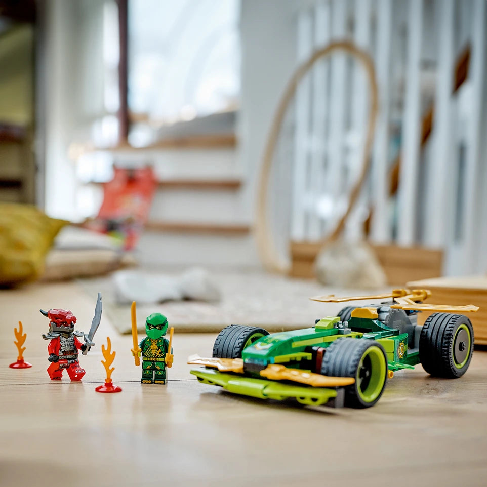 LEGO Lloyd's green and yellow pull-back race car set 71828 featuring minifigures of Lloyd in green ninja outfit and red warrior character with flame accessories on wooden floor in playroom setting
