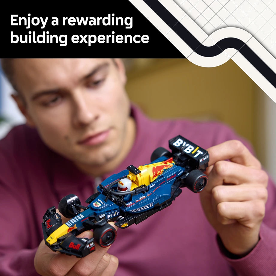 A person in a burgundy shirt holds a detailed LEGO Oracle Red Bull Racing F1 car model featuring blue, yellow, and black coloring with BYBIT branding, demonstrating the assembled buildable toy set