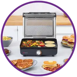 Portable grill on a table with food items around it