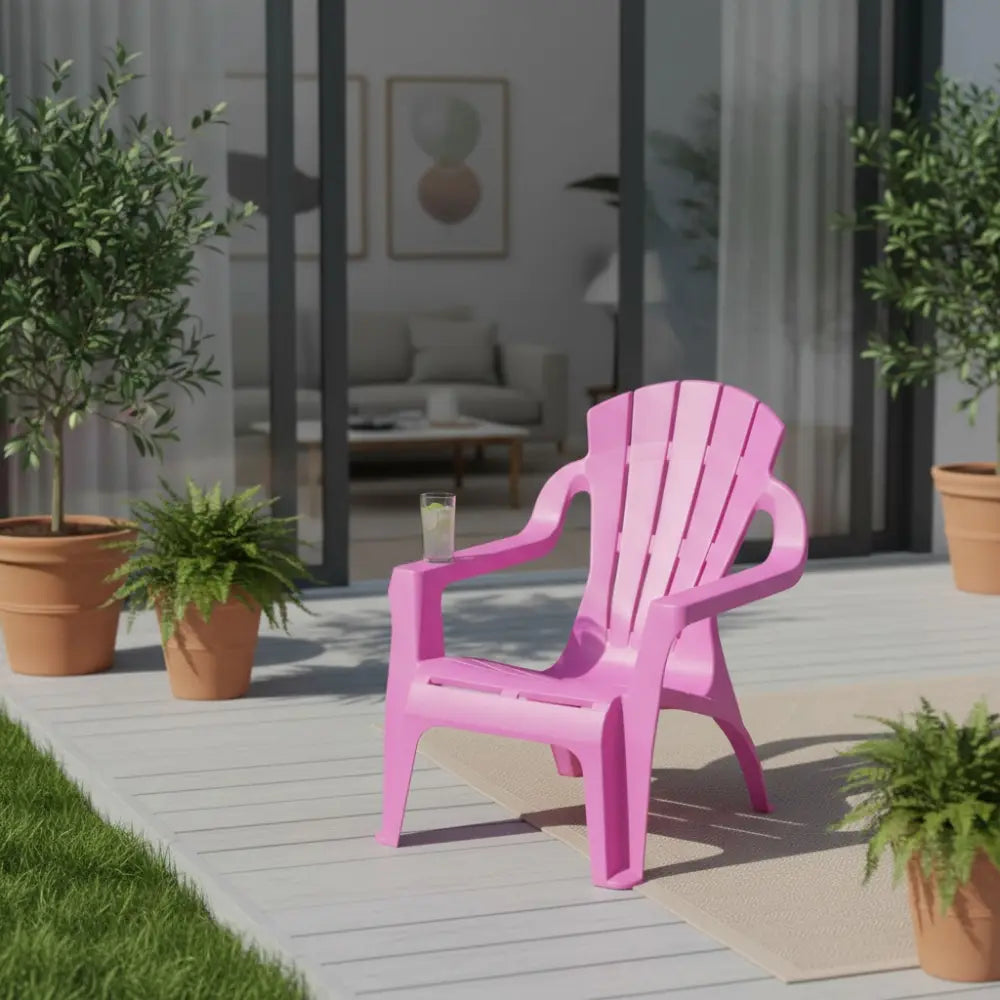 Bright fuchsia pink plastic Adirondack-style children's chair positioned on a light wooden deck surrounded by potted green plants and terracotta planters, with a modern home interior visible through glass doors in the background