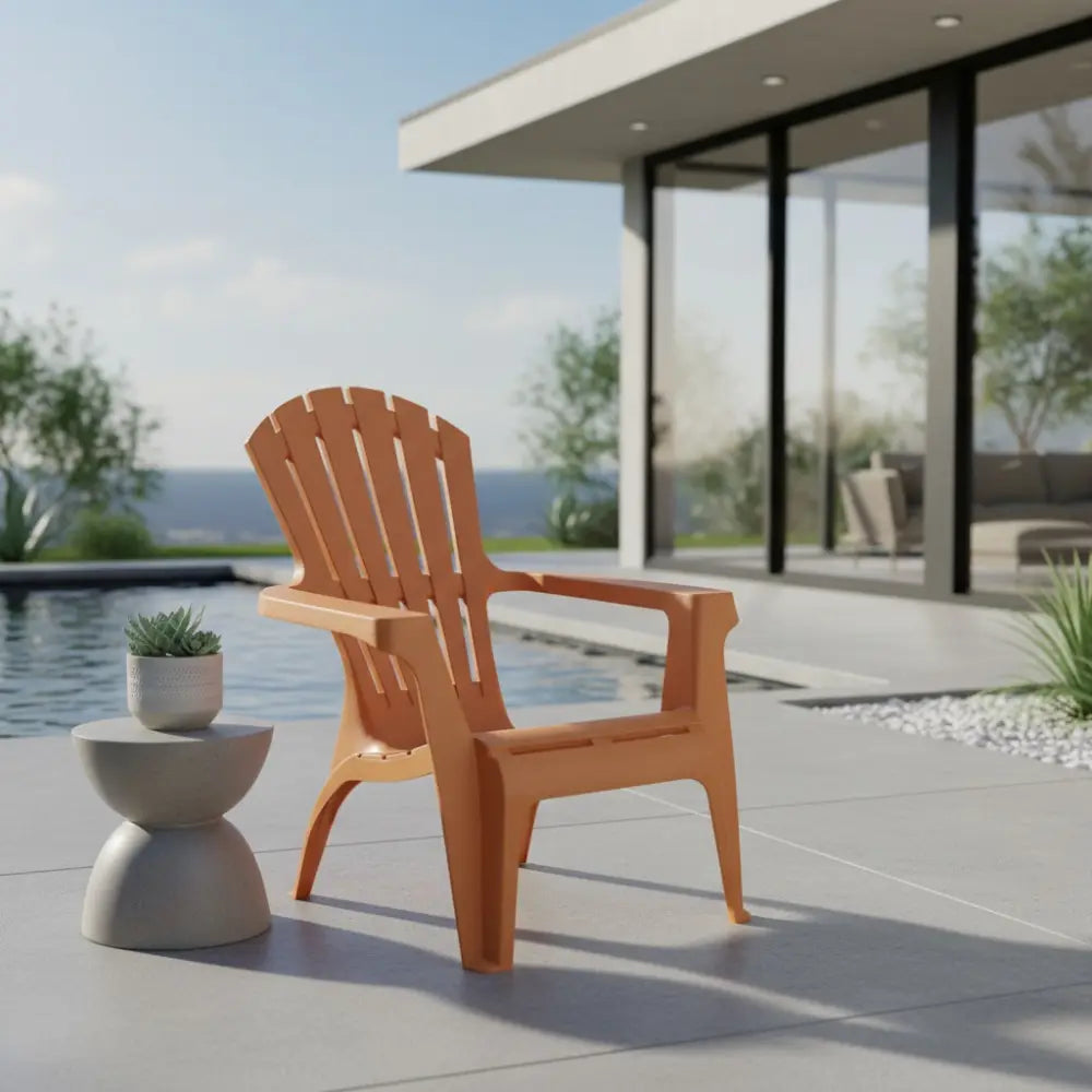 Ochre Dolomiti garden chair on a modern patio beside a pool with coastal views, featuring a white concrete side table with potted succulent and minimalist architecture in the background