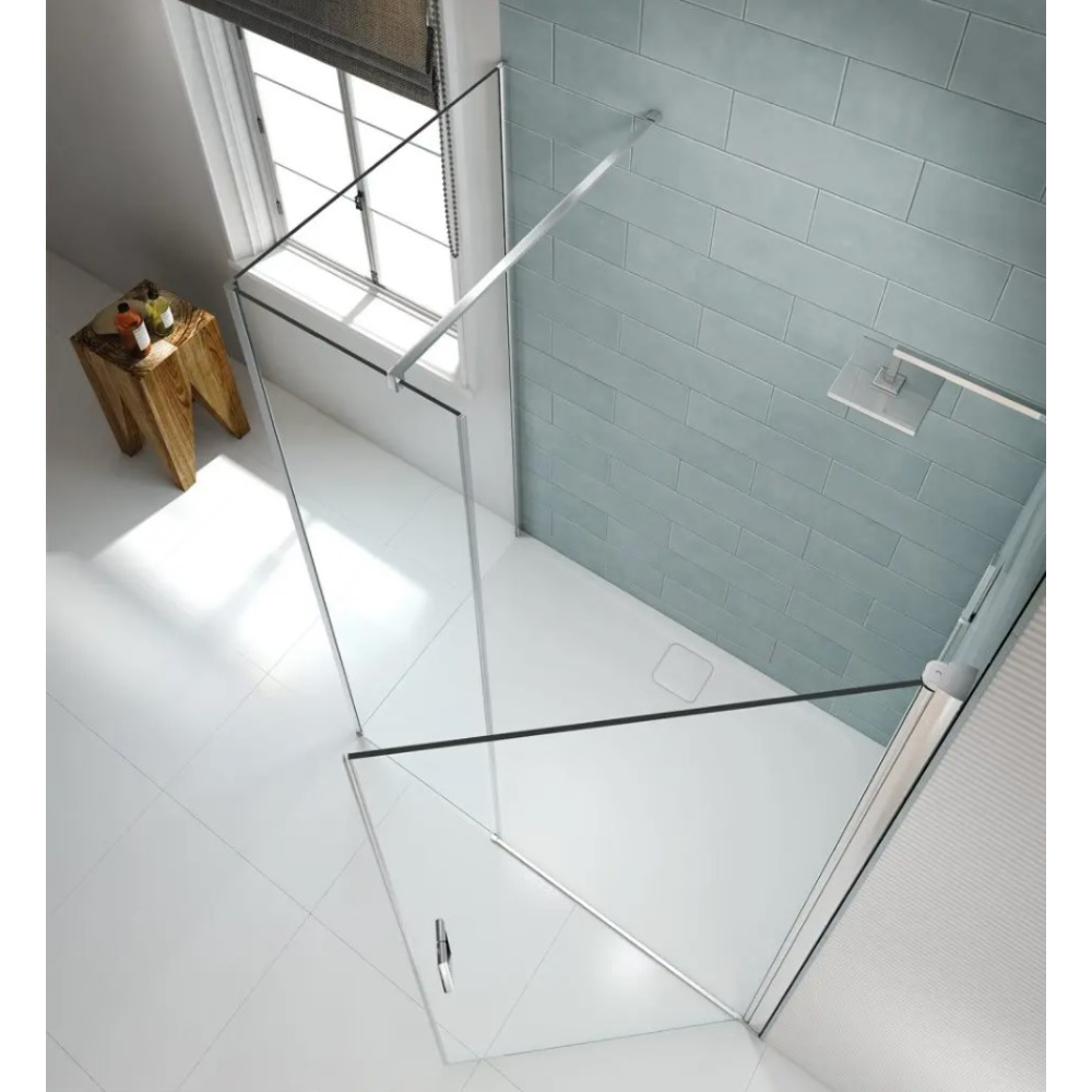 Merlyn 8 Series frameless pivot shower door with chrome hardware in modern bathroom featuring light blue subway tile walls, white floor tiles, and wooden accessories near window