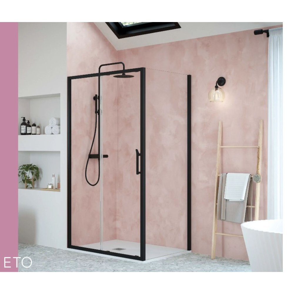 Modern black framed sliding shower enclosure with clear glass panels in pink bathroom with white freestanding bath and wooden towel ladder