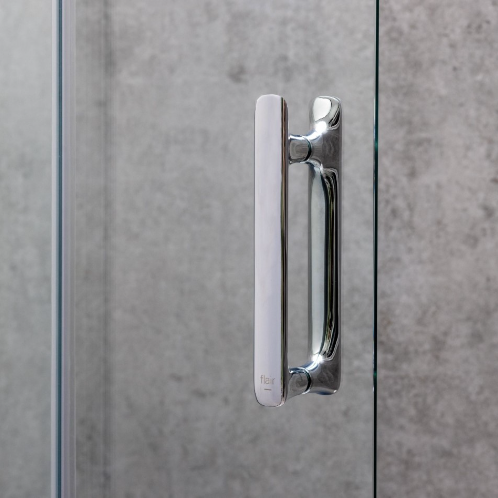 Chrome and matte black hinged shower door handle with white frame detail on concrete tile background, Flair ILI brand