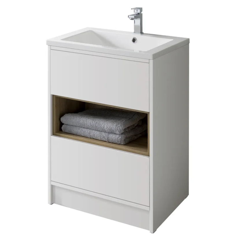 White floor standing bathroom vanity unit with integrated ceramic sink, chrome tap, open oak-effect shelf storing grey towels, and closed white storage compartment below