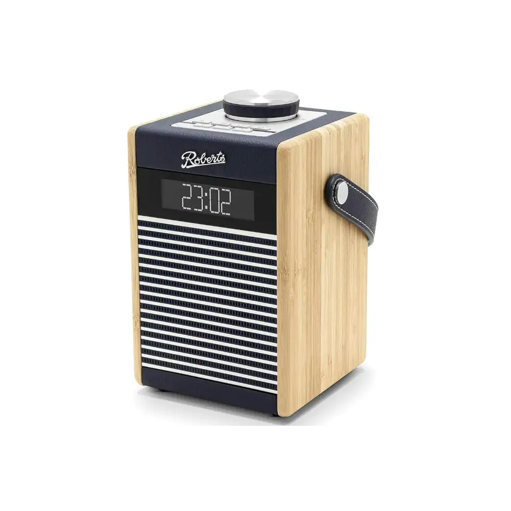 Roberts Rambler Midi DAB+ FM radio with Bluetooth in navy blue and natural wood finish, featuring digital display showing 23:02, horizontal grille speaker front, leather carry handle, and chrome tuning knob