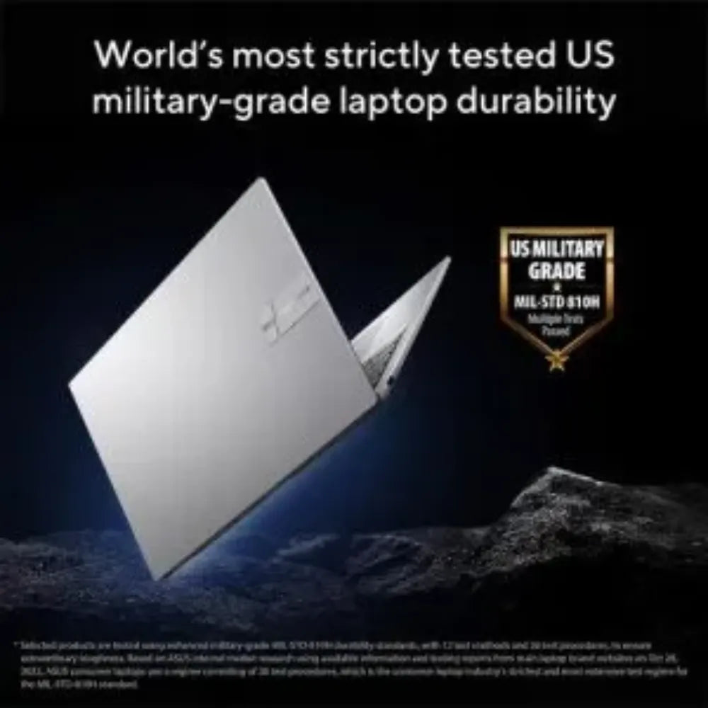 Silver ASUS Vivobook laptop tilted at angle on rocky surface with US Military Grade MIL-STD-810H durability certification badge displayed against dark background