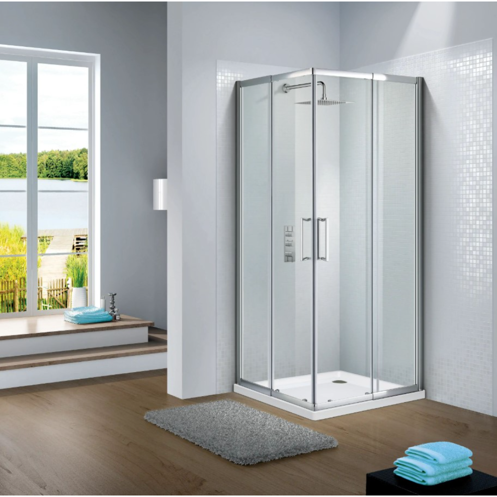 Modern chrome framed corner entry shower enclosure with clear glass panels and white tray, installed in bright bathroom with white tile walls, wooden flooring, and scenic window view