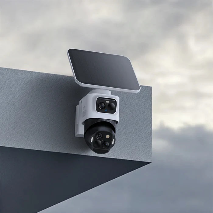 Security camera system with solar panel on a metallic surface against a cloudy sky.