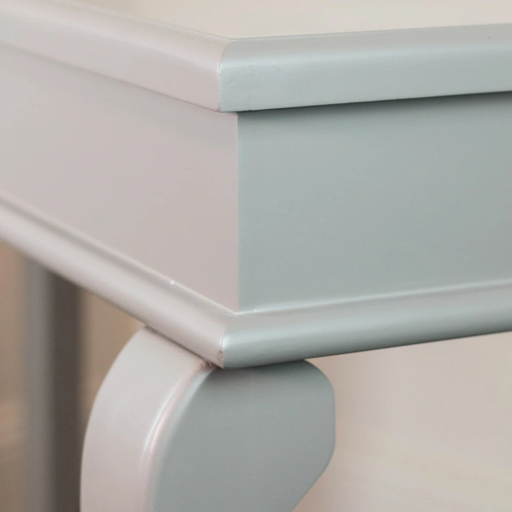 Close-up detail of Tara Lane Scroll Console Table showing mink grey painted finish with white decorative scroll bracket support and curved edge banding on light neutral background