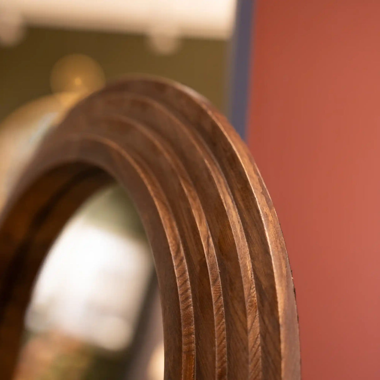 Close-up detail of natural wood frame showing curved arch design and vertical grain texture on Tara Lane stepped arched floorstanding mirror