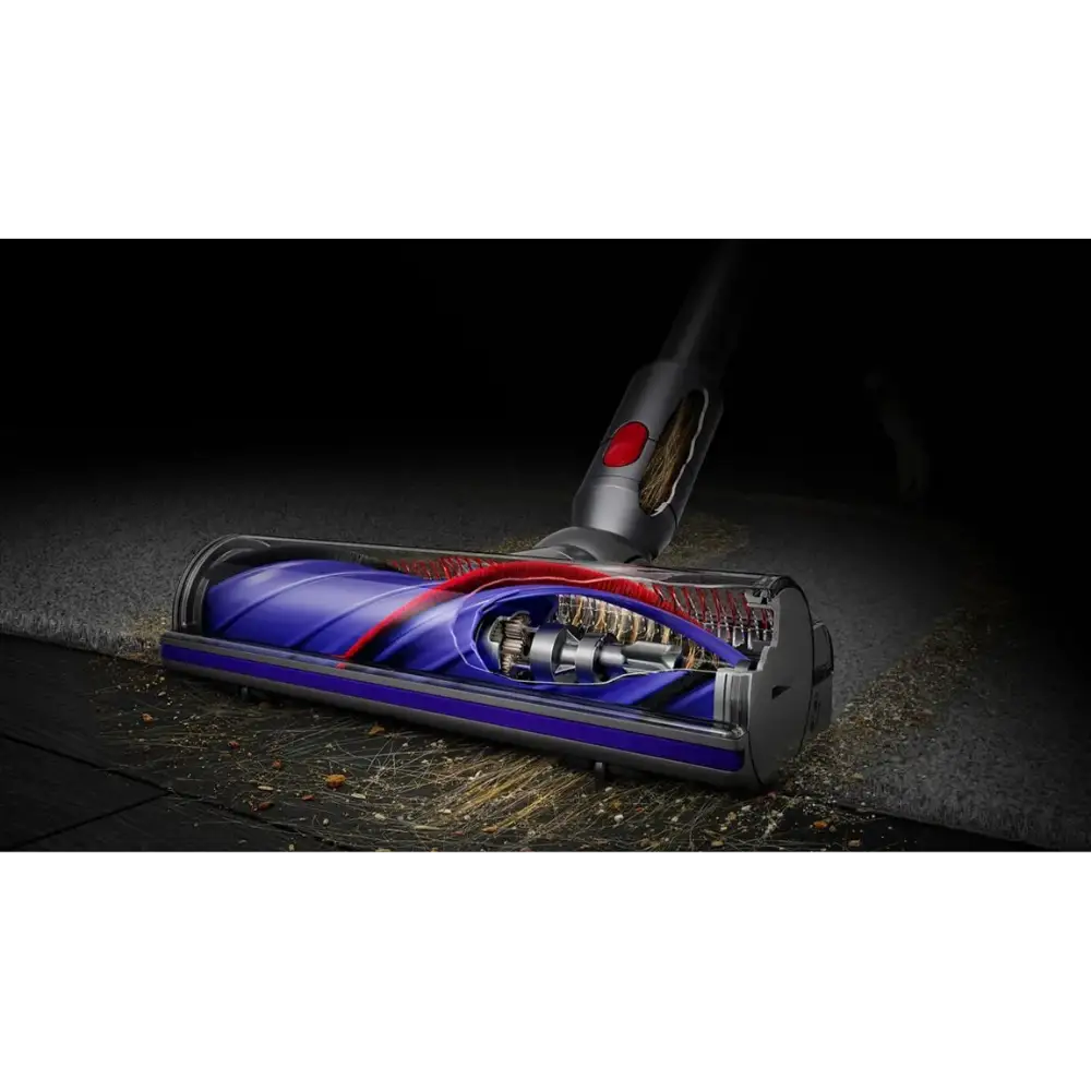 Dyson Cyclone V10 Submarine cordless stick vacuum cleaner with blue and red cyclone chamber, black handle with red button, shown on wet floor with debris and water droplets