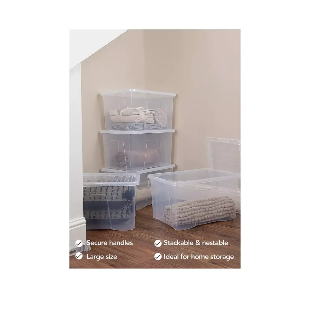 Clear plastic storage boxes with secure handles stacked and nested, containing folded linens and household items on wooden floor against beige wall, showing large 60-litre capacity containers ideal for home organization