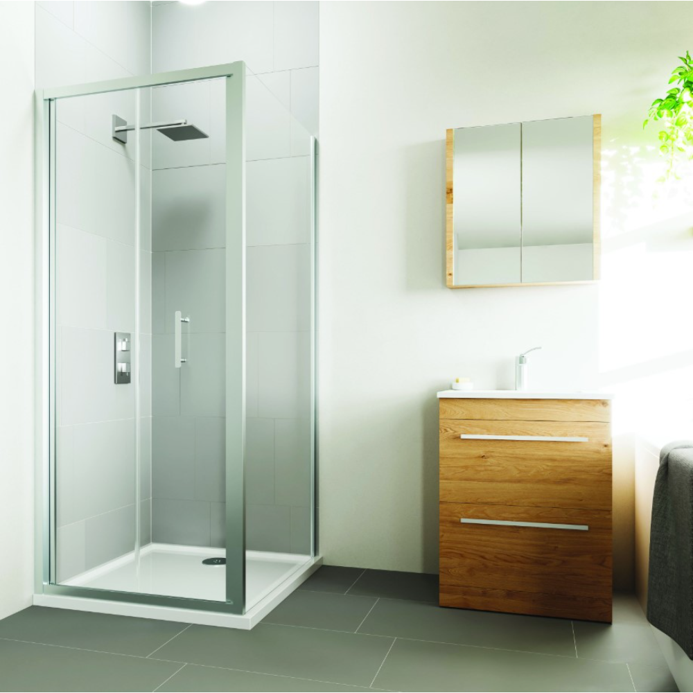 Flair VERVE PRO bifold shower door in chrome frame with frosted glass panel installed in modern bathroom with white tiles, wooden vanity unit, mirrored cabinet and dark floor tiles