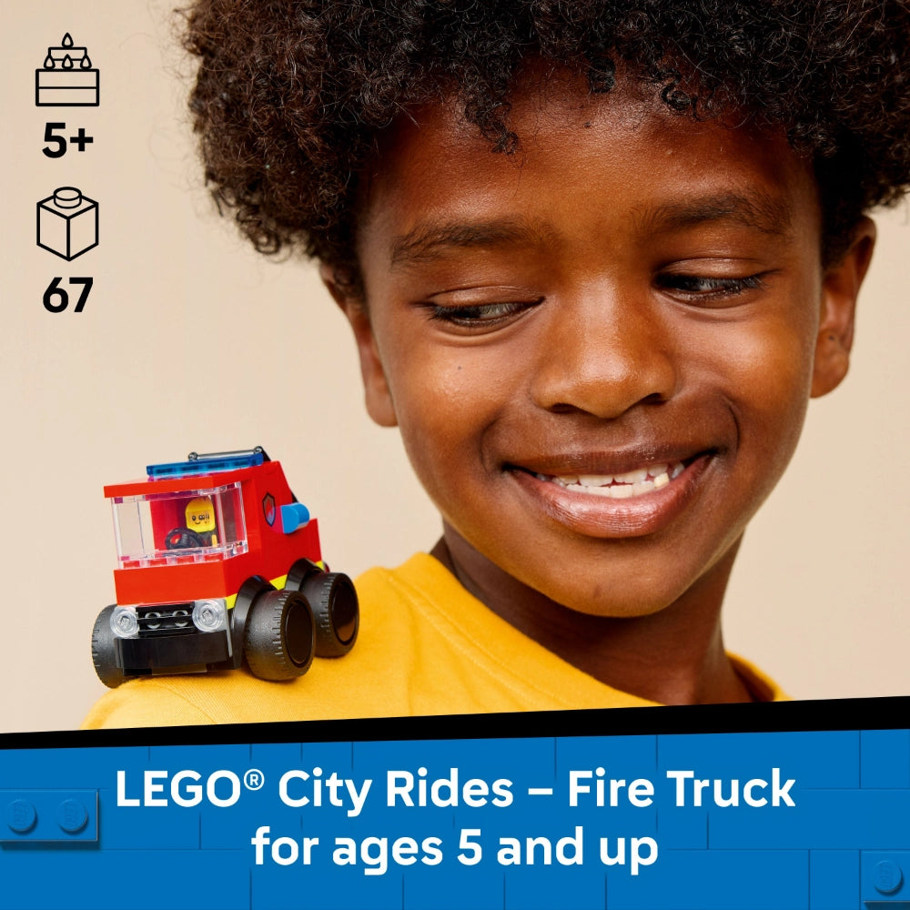 A smiling child wearing a yellow shirt holds a red LEGO City fire truck with black wheels and blue details, displayed against a beige background with age rating 5+ and 67 piece count indicators