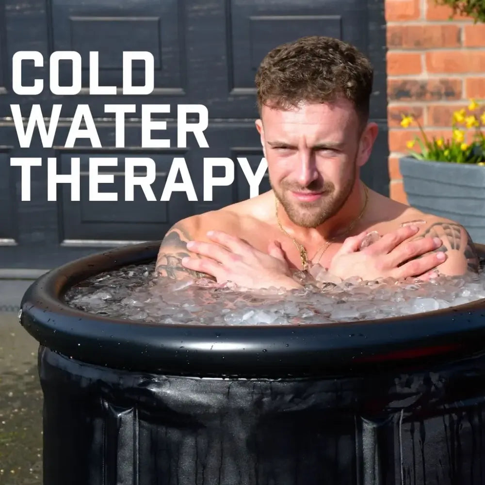 Man immersed in black Urban Fitness Recovery ice bath outdoors demonstrating cold water therapy with text overlay, brick building and dark gate visible in background
