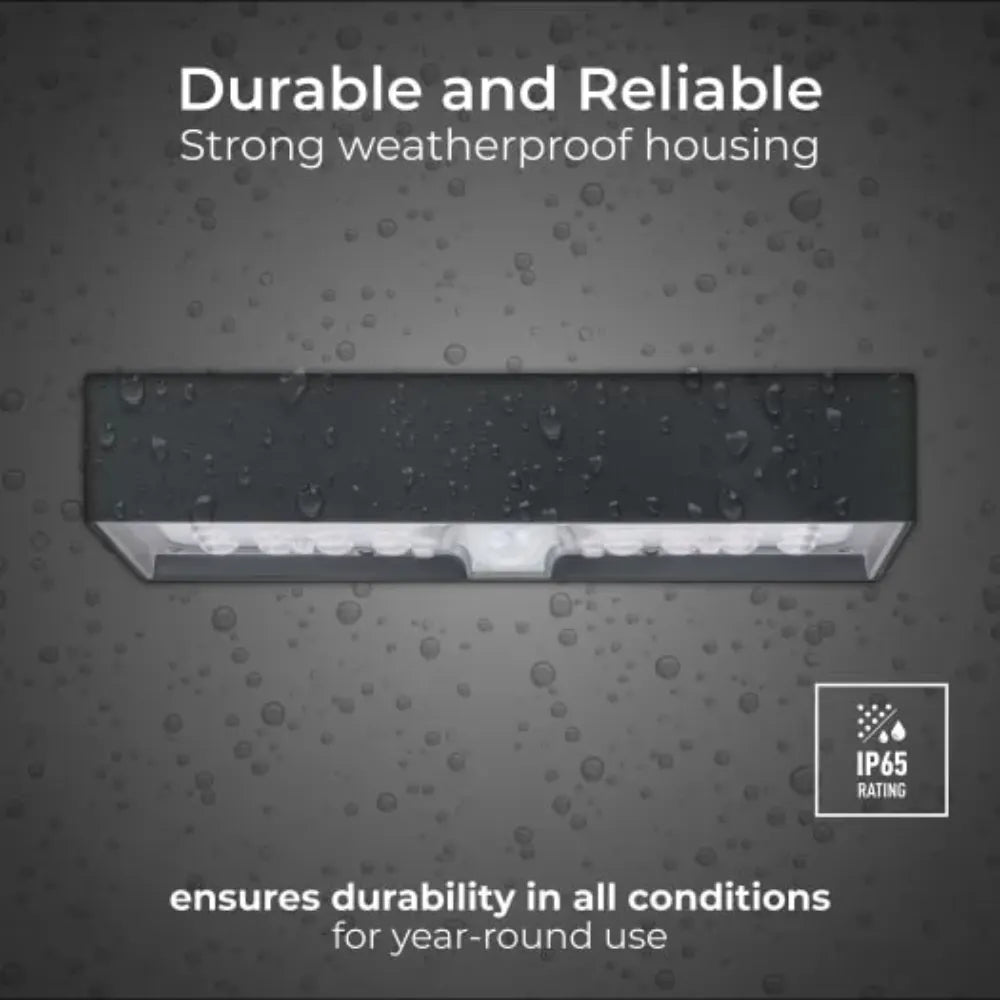 Luceco solar brick light slate grey with weatherproof housing and IP65 rating, displaying water droplets on grey background to demonstrate durability