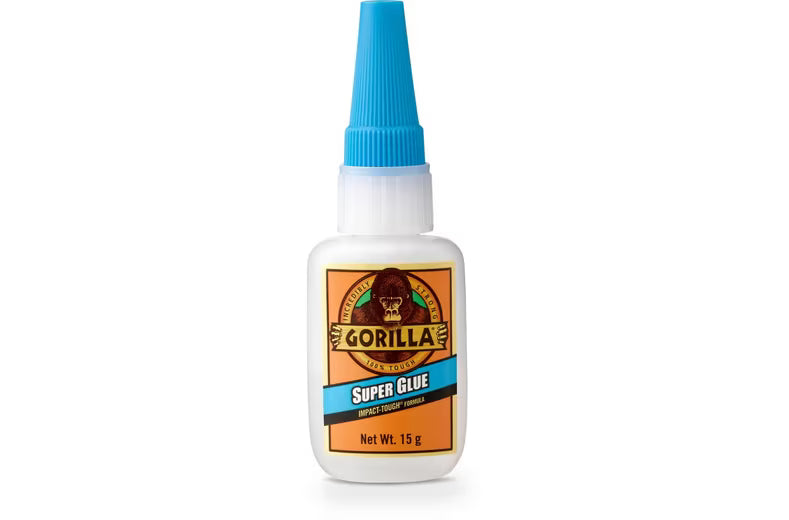 Gorilla Super Glue 15g bottle with blue cap and white label featuring gorilla logo and blue SUPER GLUE banner on orange background