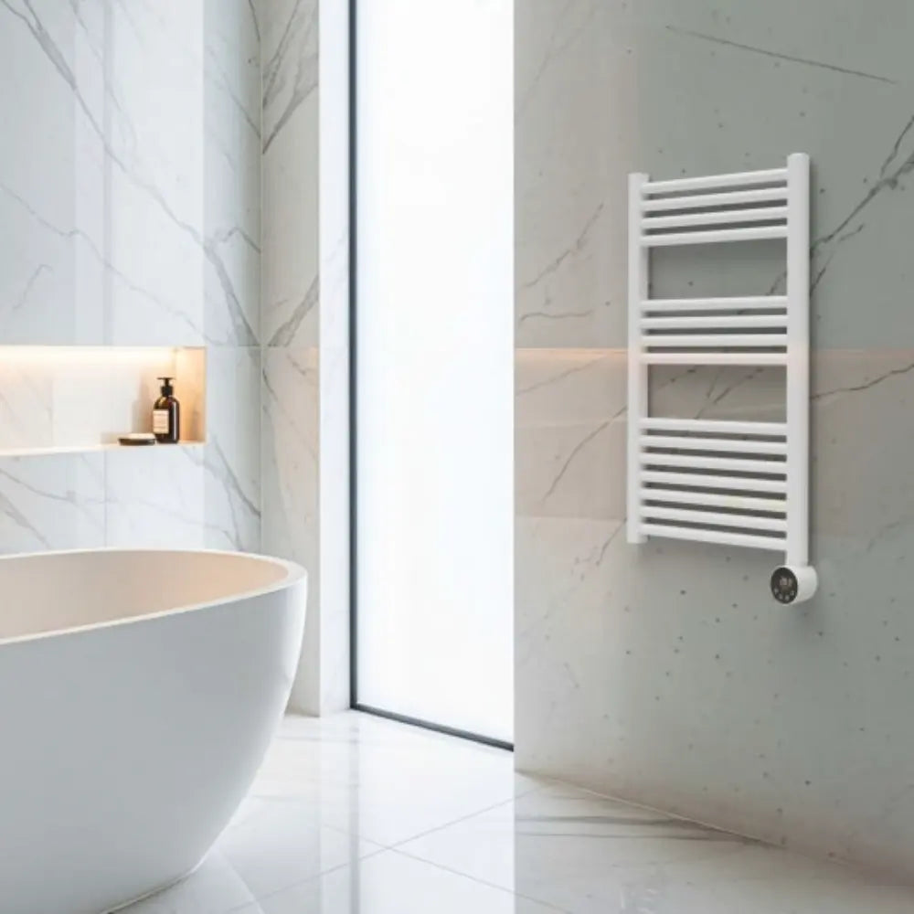 White heated towel rail with horizontal bars mounted on marble-effect wall in modern minimalist bathroom with freestanding white bathtub and skylight window