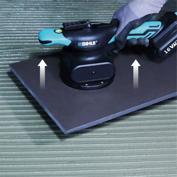 Bihui CVT Vibration Tile Beater with black body and turquoise handles mounted on dark grey base plate with white directional arrows, shown on green wooden surface with battery pack visible