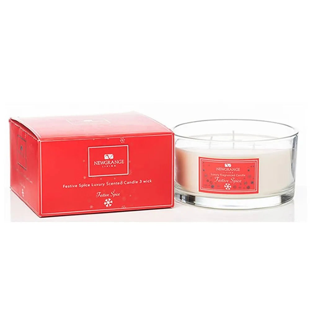 Newgrange Living Festive Spice luxury scented candle 3 wick in clear glass container with red branded label next to bright red product box packaging
