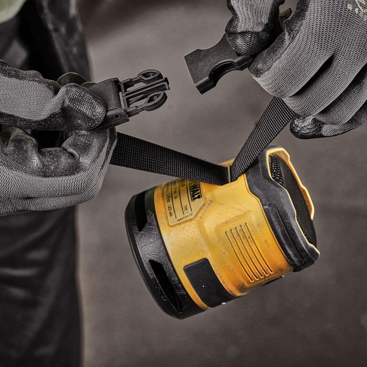 DeWalt DCR009 compact yellow and black Bluetooth speaker held in gloved hands against grey background, showing rugged industrial design with carrying strap