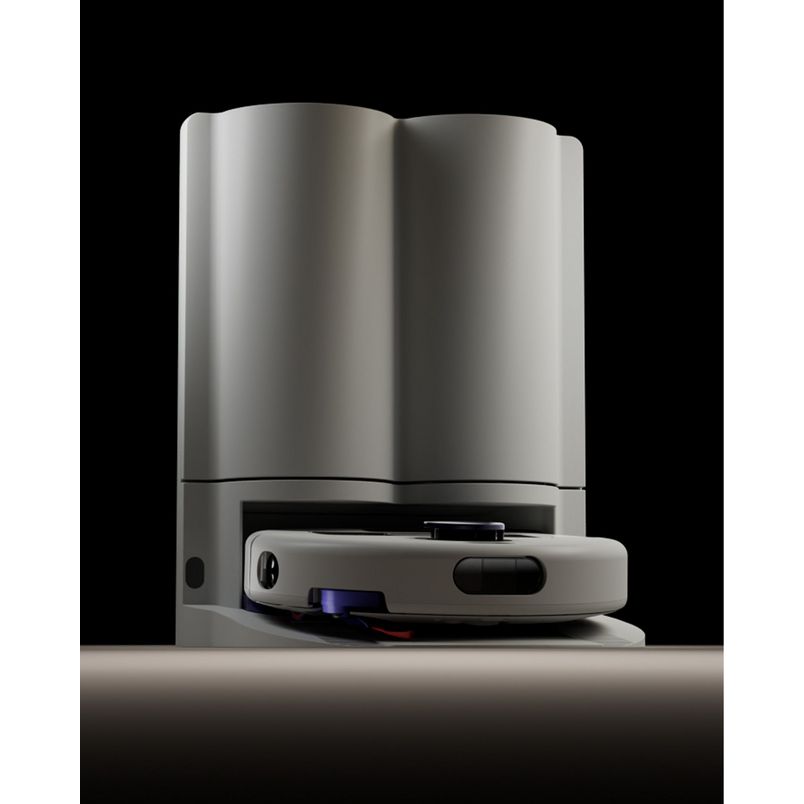 Dyson R2 Nurovi robot vacuum cleaner in silver and white with black accents, shown from front angle against black background, displaying the compact disc-shaped robotic base unit positioned in front of the tall cylindrical white docking station
