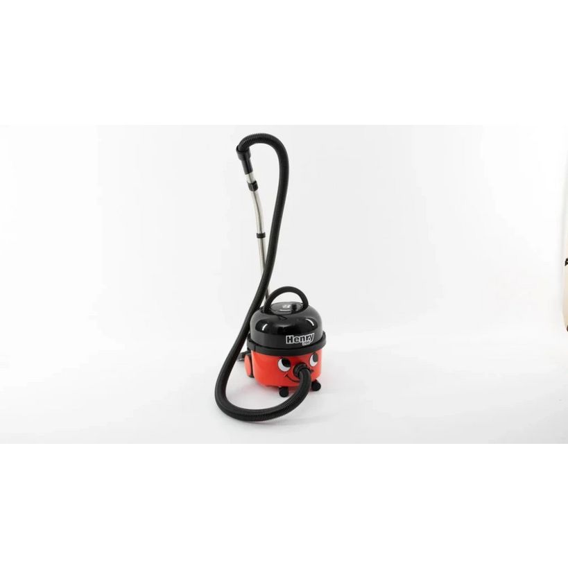 Numatic Henry red and black compact wet and dry vacuum cleaner with hose and handle on white background